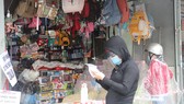Phụ huynh ghi danh sách đồ dùng học tập cần mua cho học sinh gửi vào trong quầy bán hàng để tránh tiếp tục trực tiếp