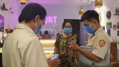 Lực lượng chức năng kiểm tra thực hiện quét mã QR tại 1 cơ sở kinh doanh dịch vụ ăn uống
