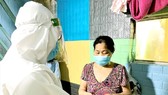 Nhân viên Trạm Y tế phường 11 (Bình Thạnh) thăm khám và cấp phát thuốc cho người bệnh tại nhà. Ảnh: BÙI TUẤN