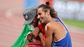 VĐV Tamberi đã ôm lấy đồng nghiệp Barshim để ăn mừng chiến thắng. Ảnh: REUTERS