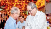 Bí thư Thành ủy TPHCM Nguyễn Thiện Nhân thăm hỏi sức khỏe ông Nguyễn Xuân Thơm (thủy thủ tàu Không số), đảng viên khu phố 1, phường 12, quận 4 Ảnh: HOÀNG HÙNG
