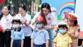 Hoa hậu Lương Thùy Linh vận động đội mũ bảo hiểm cho trẻ em
