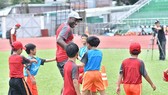 Sol Campbell thị phạm cùng các cầu thủ nhí trên sân Thống Nhất. Ảnh: ANH TRẦN