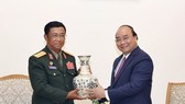 Prime Minister Nguyen Xuan Phuc (R) presents a gift to Sen. Lt. Gen. Suvon Luongbunmi, Deputy Defence Minister and Chief of the General Staff of the Lao People’s Army, at their meeting on May 14 (Photo: VNA)