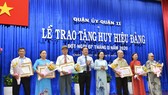Đồng chí Nguyễn Thị Lệ, Phó Bí thư Thành ủy, Chủ tịch HĐND TPHCM trao huy hiệu Đảng cho các đảng viên tại quận 11. Ảnh: VIỆT DŨNG