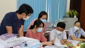 Các thành viên đoàn thực hiện kiểm tra sổ chi hỗ trợ tại các phường ở quận Tân Phú