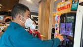 Lực lượng tuyến đầu chống dịch sử dụng mã mua hàng để chọn phần ăn tại cửa hàng McDonald's