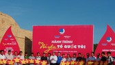 Ông Trần Văn Hiện, Chủ tịch HĐND tỉnh Cà Mau (áo trắng) và Anh Nguyễn Tường Lâm, Phó Chủ tịch Thường trực Trung ương Hội Liên hiệp Thanh niên Việt Nam (áo xanh) tặng cờ Tổ quốc cho ngư dân