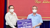 Đồng chí Trần Thanh Mẫn (bìa trái) trao bảng tượng trưng hỗ trợ kinh phí 1,5 tỷ đồng cho công tác phòng, chống dịch Covid-19 tỉnh Bạc Liêu