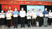 Chủ tịch HĐND TPHCM Nguyễn Thị Lệ tặng thưởng cho các tập thể chống dịch Covid-19 của quận 3. Ảnh: VIỆT DŨNG