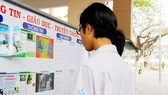 Students read poster of tobacco harm (Photo: SGGP)