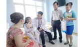 Social workers visit a kid patient to encourage her to overcome the illness (Photo: SGGP)