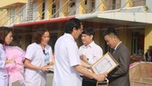 Dr. Nguyen Viet Dong gives certificates of merit to two donors (Photo: SGGP)