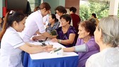 Young medical workers provide checkup to elderly people (Photo: SGGP)