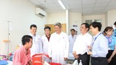 Deputy Health Minister Nguyen Truong Son pays a patient in Cho Ray Hospital a visit in the hospital (Photo: SGGP)