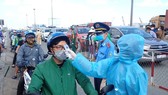 A driver has his body temperature taken before entering Ho Chi Minh City (Photo: SGGP)