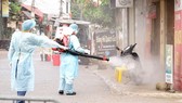 Medical workers spray disinfectant to clean the village (Photo: SGGP)
