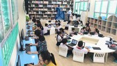 Pupils of Dong Da Primary School are reading books in the smart library. (Photo: SGGP)