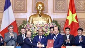 Prime Minister Nguyen Xuan Phuc (C) witnesses the signing ceremony between the Government Office of Vietnam and the French Development Agency (AFD) in e-government development cooperation (Photo: VNA)