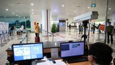 A staff member at Noi Bai International Airport in Hanoi checks passengers' body temperature via a thermal scanner (Photo: VNA)