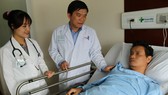 ​  Bác sĩ Cao Minh Thông thăm khám bệnh nhân sau phẫu thuật.