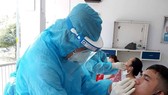 Nhân viên y tế lấy mẫu xét nghiệm cho công nhân tại Khu chế xuất Tân Thuận (quận 7)