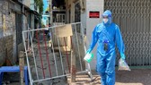 Nhân viên y tế phường Tân Quy, quận 7 phát thuốc cho bệnh nhân F0 điều trị tại nhà Ảnh: HOÀNG HÙNG
