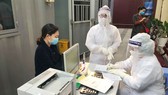  Nhân viên y tế làm thủ tục thăm khám cho người bệnh tại khu vực phòng khám "dã chiến" của Bệnh viện Phụ sản Trung ương. Ảnh: ncov.moh.gov.vn