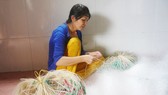 Chị Nguyễn Thị Bé Vinh dù bệnh tật vẫn gắng đan lưới kiếm tiền nuôi 2 con