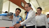 HCMC Party Chief Nguyen Thien Nhan learns about Vietnamese branded products (Photo: SGGP)