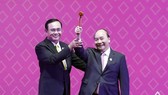 Thai Prime Minister Prayut Chan-o-cha (L) hands the chairmanship hammer to his Vietnamese counterpart Nguyen Xuan Phuc at the ceremony in Bangkok on November 4 evening (Photo: VNA)