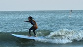 A tourist goes surfing on the sea off Hua Hin Beach in Thailand's Prachuap Khiri Khan province on December 5 (Photo: Xinhua/VNA)