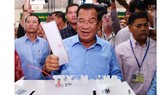 Thủ tướng Samdech Techo Hun Sen (giữa), Chủ tịch đảng Nhân dân Campuchia (CPP) cầm quyền bỏ phiếu tại điểm bầu cử ở Phnom Penh ngày 29-7. Ảnh: AFP/TTXVN