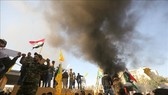 Các tay súng thuộc nhóm phiến quân Hashd al-Shaabi biểu tình bên ngoài sứ quán Mỹ ở Baghdad, Iraq ngày 31-12-2019. Ảnh: AFP/TTXVN