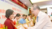 Bí thư Thành ủy TPHCM Nguyễn Thiện Nhân trao bằng khen cho các tập thể đạt thành tích xuất sắc trong công tác tuyên giáo. Ảnh: VIỆT DŨNG