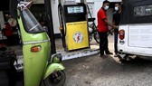 Nhân viên đổ xăng cho xe ôtô tại một trạm xăng dầu ở Colombo. Ảnh: AFP