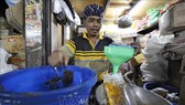 Người dân đong dầu ăn để bán tại một khu chợ ở Jakarta, Indonesia. Ảnh: AFP/TTXVN