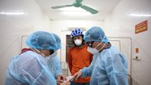 Bàn giao du khách Z. L. (áo đỏ) cho Bệnh viện Đa khoa Hà Tĩnh để tiến hành cách ly, theo dõi trong khi chờ kết quả xét nghiệm