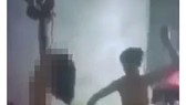 Hình ảnh cháu bé không mặc áo quần, hai tay bị trói treo lên trần nhà. Ảnh cắt lại từ video clip