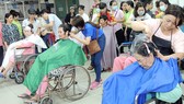 Các tình nguyện viên cắt tóc cho bệnh nhân