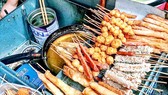 Những món quà vặt bắt mắt không rõ xuất xứ, thiếu an toàn vệ sinh thực phẩm vẫn tràn lan trước cổng các trường học. Ảnh: THANH MAI