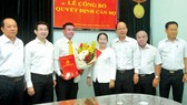 Phó Bí thư Thành ủy TPHCM Võ Thị Dung trao quyết định  và tặng hoa chúc mừng đồng chí Lê Kim Hiếu. Ảnh: CAO THĂNG