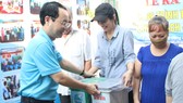 Bí thư Quận ủy quận 5 Nguyễn Văn Hiếu tặng thùng rác cho các hộ gia đình  tại lễ ra mắt hẻm xanh - sạch - văn minh  ở phường 1, quận 5. Ảnh: MAI HOA