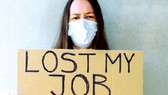 Một người lao động thất nghiệp ở Mỹ cầm tấm bìa ghi:  Tôi mất việc làm vì Covid-19