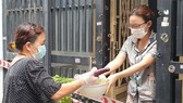 Người dân trong khu phong tỏa  tại quận Tân Phú (TPHCM)  được chăm lo thực phẩm,  an tâm ở nhà phòng chống dịch. Ảnh: THÁI PHƯƠNG