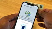 Người dân kích hoạt tài khoản định danh điện tử VNeID qua tính năng NFC của điện thoại thông minh. Ảnh: HOÀNG HÙNGoàng