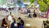 Người trẻ vô tư ngồi bệt ở phố đi bộ Nguyễn Huệ (quận 1) để ăn uống và xả rác