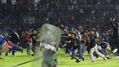 Cổ động viên tràn xuống sân vận động Kanjuruhan ở thành phố Malang, tỉnh Đông Java, Indonesia, tối 1-10, gây ra tình trạng hỗn loạn. Ảnh: AP