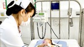 Bác sĩ Bệnh viện Nhi đồng 2 (TPHCM) thăm khám  cho bệnh nhi bị viêm hô hấp