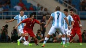 Tuấn Anh trong vòng vây của các cầu thủ Argentina